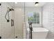Bathroom with glass shower, subway tile, soaking tub, and black fixtures at 2508 Haddenham Sw Ln, Smyrna, GA 30082