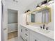 Bathroom with white cabinets, a double vanity, and a large mirror with modern lights at 2508 Haddenham Sw Ln, Smyrna, GA 30082