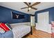 Navy blue themed bedroom featuring hardwood floors, a ceiling fan, and a unique design aesthetic at 2508 Haddenham Sw Ln, Smyrna, GA 30082