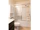 Bathroom with a white shower-tub combo and sliding glass doors at 6695 Grove Meadows Ln, Cumming, GA 30028