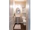 Well-lit bathroom featuring a stylish sink, toilet, and storage shelf unit at 6695 Grove Meadows Ln, Cumming, GA 30028