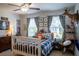 Welcoming bedroom with a themed decor, window and ceiling fan offers a personalized touch and comfort at 6695 Grove Meadows Ln, Cumming, GA 30028