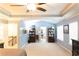 Spacious primary bedroom with tray ceiling, ceiling fan, and adjoining bathroom at 6695 Grove Meadows Ln, Cumming, GA 30028