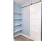 Walk in closet with light blue walls, open shelving, and a sliding barn door at 6695 Grove Meadows Ln, Cumming, GA 30028