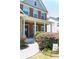Inviting front entrance with a covered porch, brick facade, decorative bushes, and a walkway at 6695 Grove Meadows Ln, Cumming, GA 30028