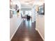 Bright hallway featuring hardwood floors, neutral walls adorned with framed artwork, and open access to a cozy living area at 6695 Grove Meadows Ln, Cumming, GA 30028