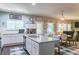Stylish kitchen featuring a granite countertop island with seating, white cabinets, stainless steel appliances, and a dining area at 6695 Grove Meadows Ln, Cumming, GA 30028