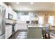 Modern kitchen featuring white cabinets, granite countertops, stainless steel appliances, and an island with bar seating at 6695 Grove Meadows Ln, Cumming, GA 30028