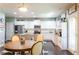 Well-lit kitchen featuring a central island, white cabinets, stainless steel appliances, and a wooden dining table at 6695 Grove Meadows Ln, Cumming, GA 30028
