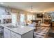Open-concept kitchen with an island and bar seating, a dining area, and a seamless transition into the living room at 6695 Grove Meadows Ln, Cumming, GA 30028