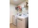 Bright laundry room featuring modern white appliances and shelving for storage at 6695 Grove Meadows Ln, Cumming, GA 30028