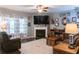 Comfortable living room with hardwood floors, a fireplace, natural light, and decorative accents at 6695 Grove Meadows Ln, Cumming, GA 30028