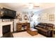 Cozy living room with hardwood floors, a fireplace, comfortable leather furniture, and decorative wall art at 6695 Grove Meadows Ln, Cumming, GA 30028