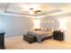 Spacious main bedroom with tray ceilings, a ceiling fan and neutral decor for a calming retreat at 6695 Grove Meadows Ln, Cumming, GA 30028