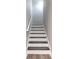 Crisp white staircase with wooden treads and handrail leads upwards, complemented by fresh paint and wood floors at 6695 Grove Meadows Ln, Cumming, GA 30028
