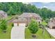 Charming brick two-story home with manicured lawn and three-car garage, nestled among lush trees at 1211 Fawndale Nw Dr, Kennesaw, GA 30152