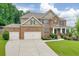 Inviting two-story brick home with a well-manicured lawn, two-car garage, and a charming front porch at 1211 Fawndale Nw Dr, Kennesaw, GA 30152