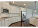 Bright kitchen features stainless steel appliances, granite counters, white cabinets, and dark hardwood floors at 1211 Fawndale Nw Dr, Kennesaw, GA 30152