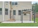Concrete patio with pergola leading to a cozy home exterior and grassy backyard at 1211 Fawndale Nw Dr, Kennesaw, GA 30152