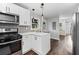 Open kitchen with stainless steel appliances, center island, and view to dining room at 1261 Calhoun Sw Ter, Atlanta, GA 30314