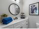 Bathroom with a single vanity, black hardware, round mirror, and a plant at 2328 Mason Drive Dr, Atlanta, GA 30316