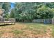 This shot showcases the backyard with a deck, trees, swing set, and fence at 127 Muirwood Dr, Temple, GA 30179