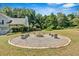 Stone firepit with seating benches providing a cozy outdoor gathering spot for relaxation and entertainment at 127 Muirwood Dr, Temple, GA 30179
