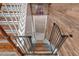 View of stairs leading to basement, featuring wood flooring and safety gate at 127 Muirwood Dr, Temple, GA 30179