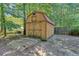 A large wooden storage shed in backyard offers organized storage for tools and outdoor equipment at 127 Muirwood Dr, Temple, GA 30179