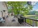 Large wooden deck overlooks a peaceful lake, featuring a grill and outdoor seating area at 177 Coopers Pond Dr, Lawrenceville, GA 30044