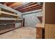 Unfinished basement with exposed ceiling and brick walls, featuring wooden shelves at 1832 Tree Top Ct, Marietta, GA 30062