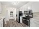 Bright kitchen featuring white cabinetry, stainless steel appliances, and wood-look flooring at 1832 Tree Top Ct, Marietta, GA 30062