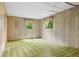 A spare room with wood-paneled walls, two windows, and green carpet at 1832 Tree Top Ct, Marietta, GA 30062