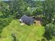 Aerial view features a house with a generous green lawn and mature trees at 28 Fawn Ct, Sharpsburg, GA 30277