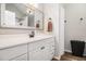Bright bathroom with a white vanity, decorative mirror and wood-look flooring at 28 Fawn Ct, Sharpsburg, GA 30277