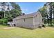Back of the home featuring neutral siding, a small deck, and a lush yard, creating a serene outdoor space at 28 Fawn Ct, Sharpsburg, GA 30277