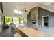 Spacious outdoor patio with a stone fireplace, ceiling fan, and comfortable seating for entertaining at 4380 Serenity Lake Dr, Cumming, GA 30028
