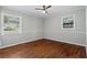 Inviting bedroom with hardwood floors, a ceiling fan, and ample natural light from two windows at 4090 Tara Dr, Forest Park, GA 30297