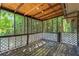 Enclosed porch featuring wooded view and decorative white latticework at 4090 Tara Dr, Forest Park, GA 30297