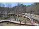Aerial view of a pedestrian bridge spanning a river, surrounded by trees at 125 Spring Dr, Roswell, GA 30075