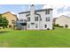 Backyard view of a white two-story home with a deck and a spacious lawn at 5003 Pacific Dunes Dr, Suwanee, GA 30024