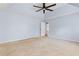 Spacious bedroom with neutral carpet, ceiling fan and walk-in closet door at 5003 Pacific Dunes Dr, Suwanee, GA 30024