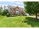 Charming two-story brick home boasts a lush green lawn, mature trees, and inviting curb appeal at 5003 Pacific Dunes Dr, Suwanee, GA 30024