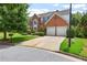 Well-maintained two-story brick home with a two-car garage, lush lawn, and mature trees at 5003 Pacific Dunes Dr, Suwanee, GA 30024