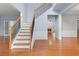 Bright foyer showcasing hardwood floors, staircase with iron spindles, and open access to living spaces at 5003 Pacific Dunes Dr, Suwanee, GA 30024