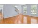 Bright and airy living space highlighting hardwood floors, large windows, and neutral wall paint at 5003 Pacific Dunes Dr, Suwanee, GA 30024