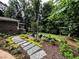 Backyard with stone path leading to an outdoor seating area surrounded by mature trees at 1620 Stonecliff Dr, Decatur, GA 30033