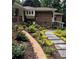 Home exterior featuring brick accents, stone pathway, and lush landscaping at 1620 Stonecliff Dr, Decatur, GA 30033