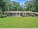 Ranch style home with large front lawn and an outdoor sitting area at 1620 Stonecliff Dr, Decatur, GA 30033