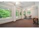 Bright sunroom with large windows showcasing green landscaping, complemented by elegant trim and a tray ceiling at 1620 Stonecliff Dr, Decatur, GA 30033